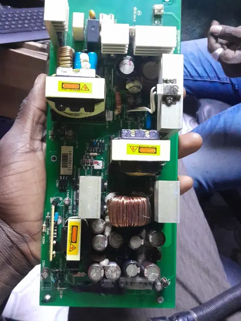 Technicien THOR tenant une carte d'alimentation industrielle reparee
